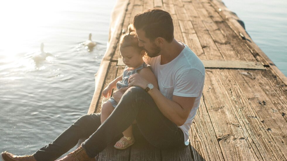 father and young son at on a dock at the lake