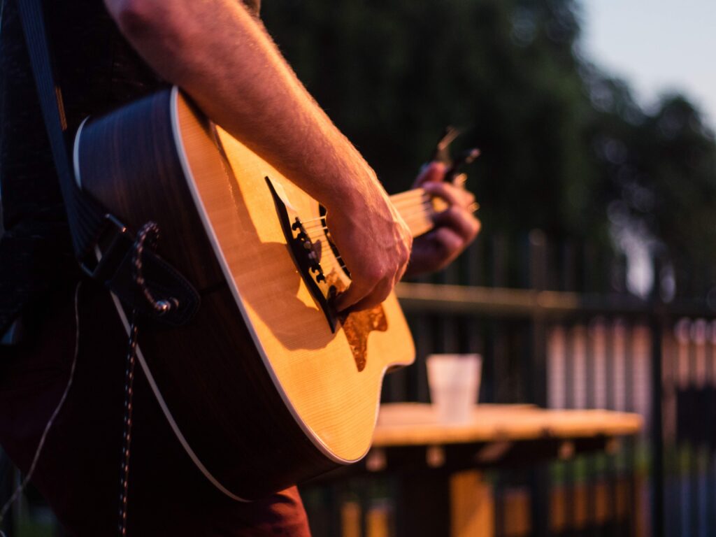 man playing guitar at sunset
