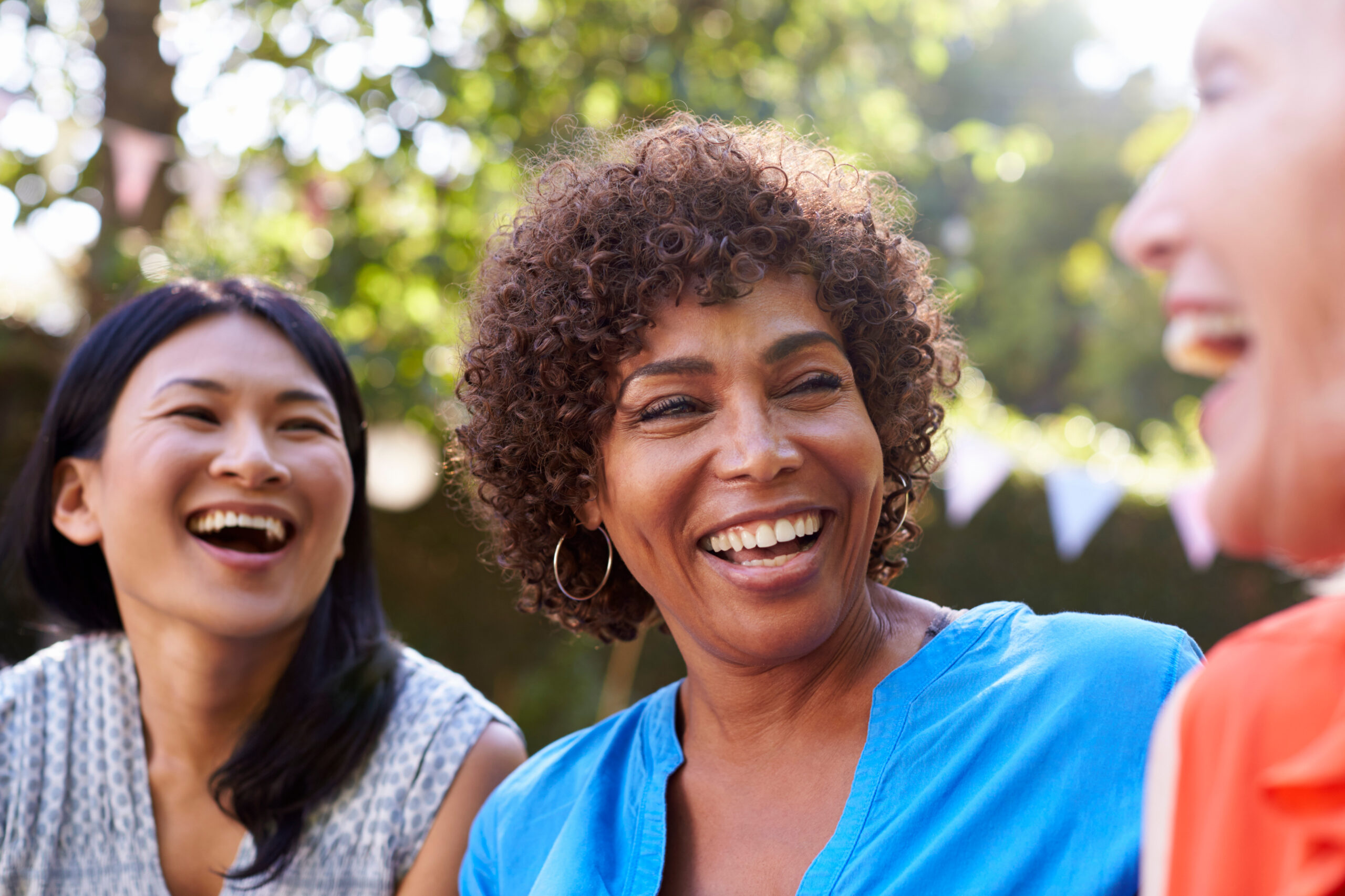 Mature Female Friends Socializing In Backyard Together