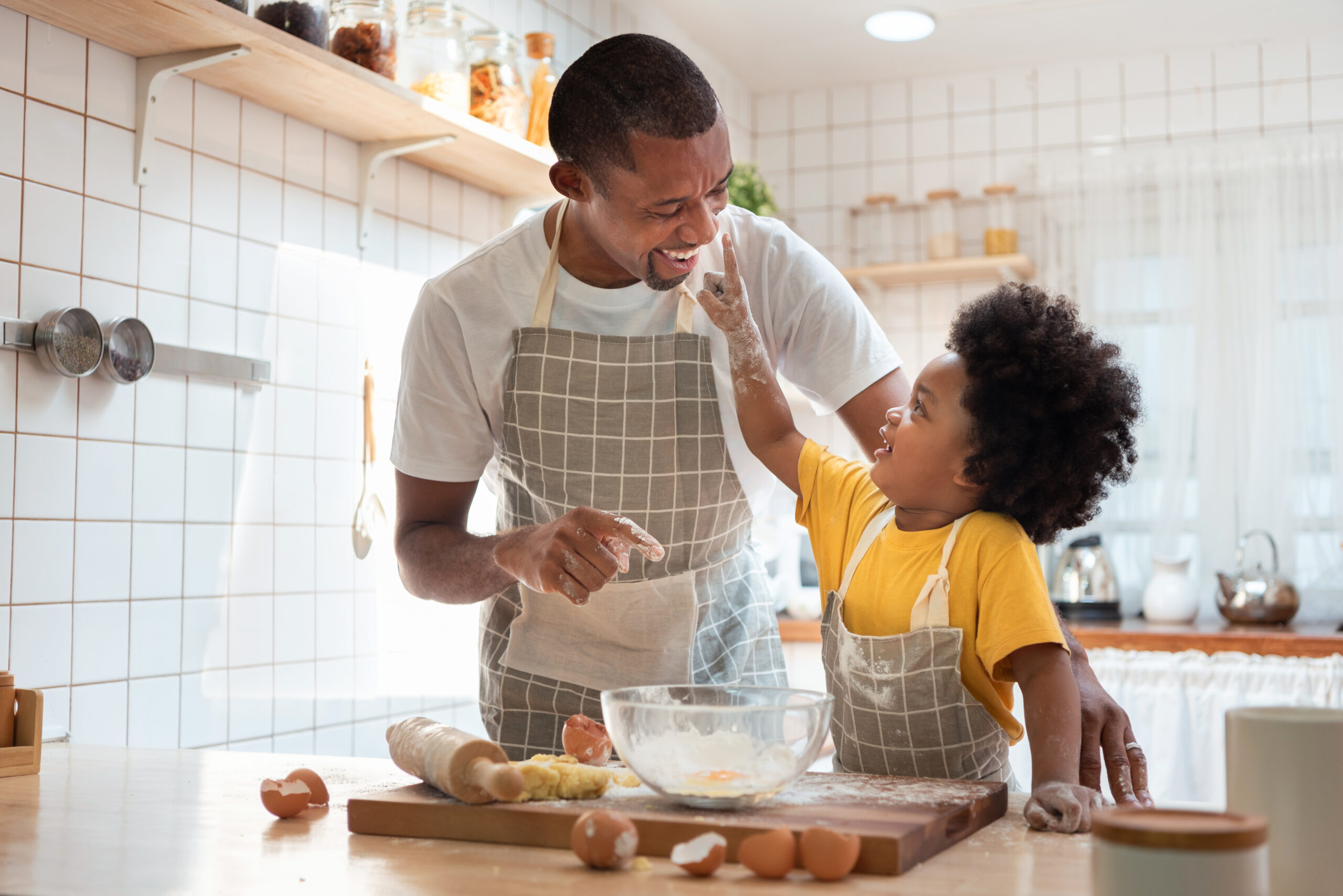 father and son enjoying during bake cookies at home together